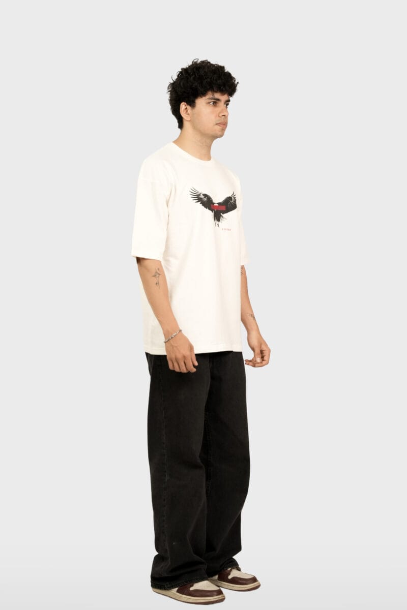 Angled lifestyle view of the model wearing the cream Defend Eagle Tee.
